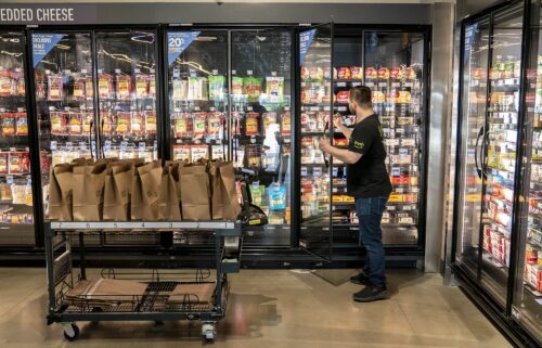 A worker picks up customer orders at an Amazon Fresh grocery store in Seattle