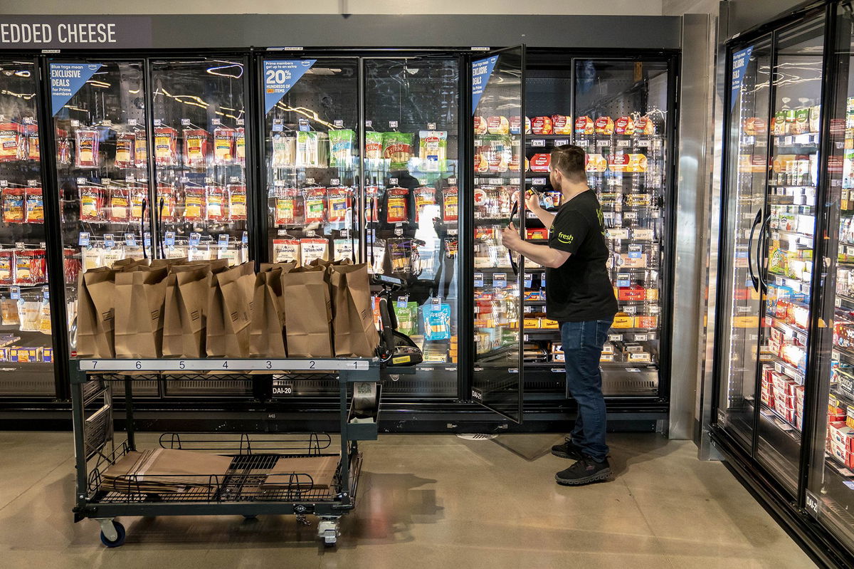 <i>David Ryder/Bloomberg/Getty Images via CNN Newsource</i><br/>A worker picks up customer orders at an Amazon Fresh grocery store in Seattle