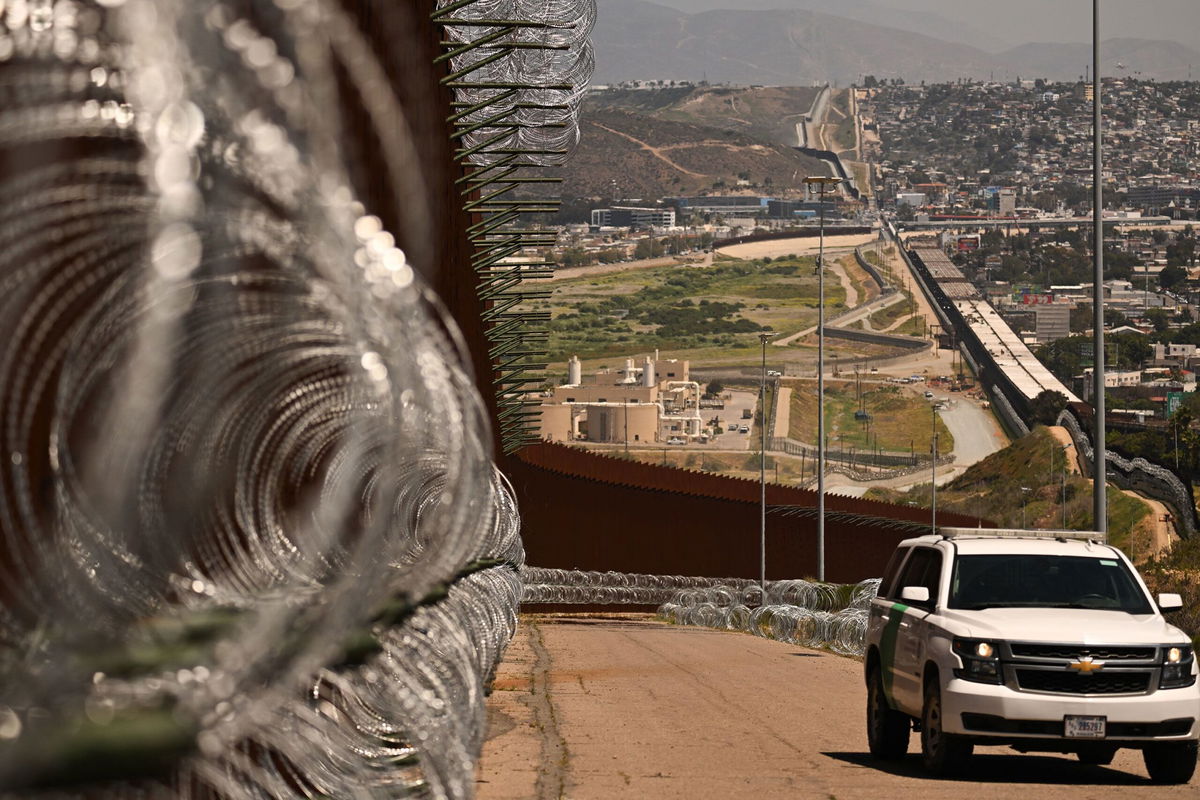<i>Patrick T. Fallon/AFP via Getty Images via CNN Newsource</i><br/>A US Customs and Border Protection (CBP) Border Patrol vehicle drives past recently installed concertina wire along the US-Mexico border between San Diego and Tijuana in San Diego