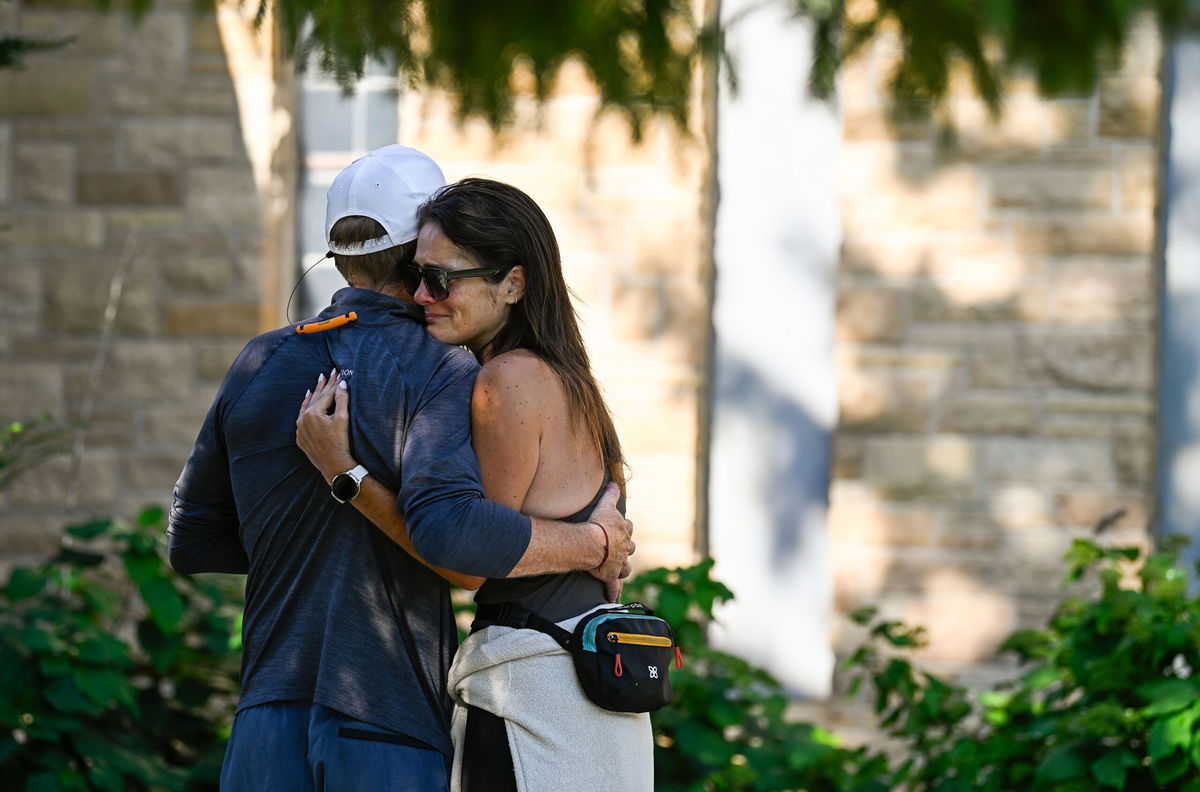 <i>Stephen Maturen/Getty Images via CNN Newsource</i><br/>Michael Burt (L) and Kristen Neville (R) embrace outside Annunciation Catholic School following a mass shooting there in Minneapolis