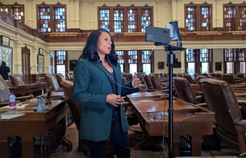 State Rep. Nicole Collier talks on the phone from the floor of the House