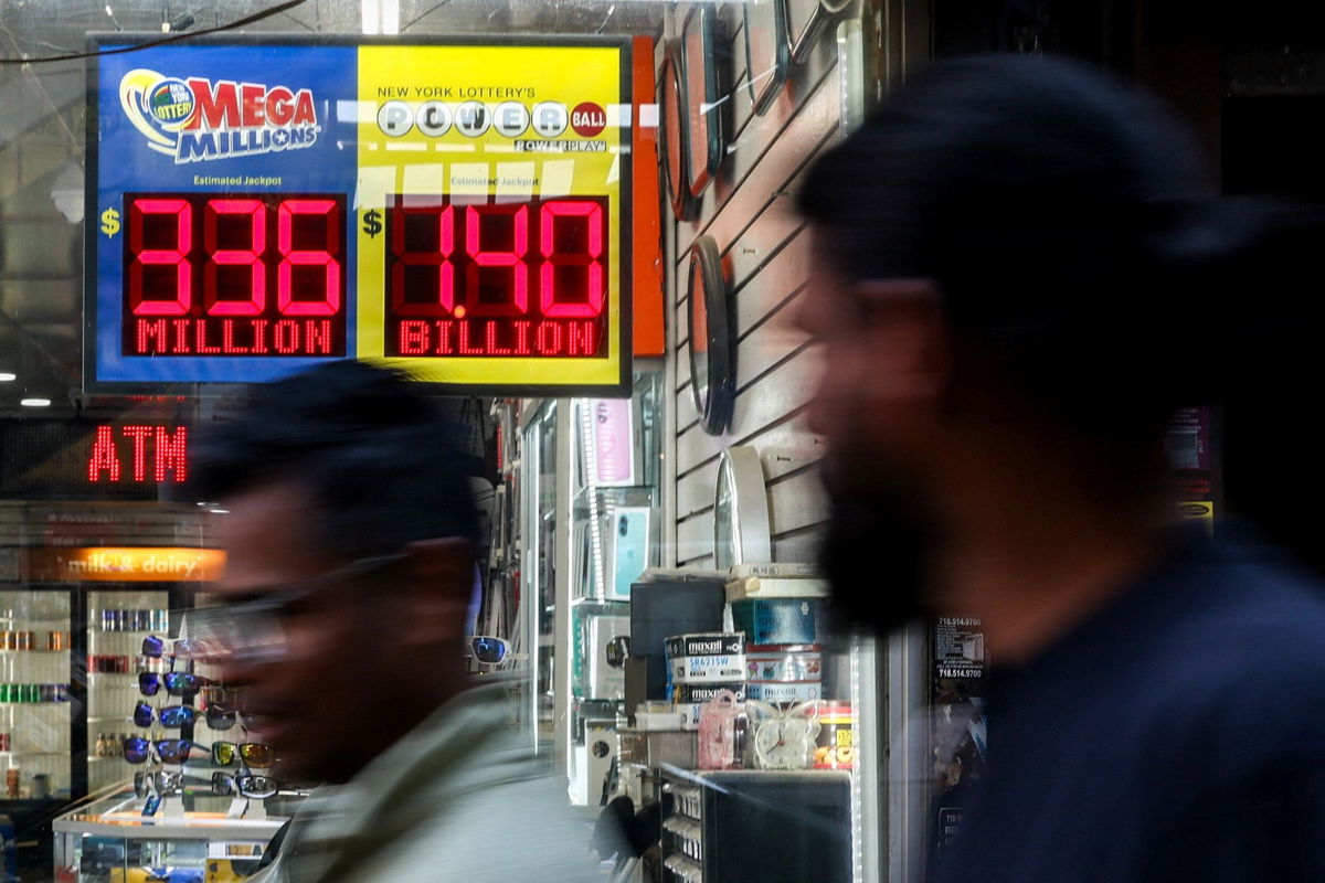<i>Kylie Cooper/Reuters via CNN Newsource</i><br/>People walk past an electronic sign displaying the $1.4 billion jackpot in the Powerball lottery drawing in Queens