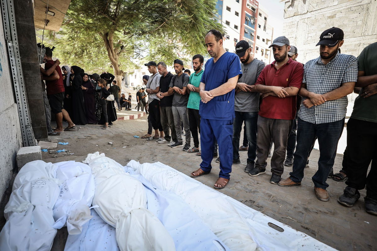 <i>Khames Alrefi/Anadolu/Getty Images via CNN Newsource</i><br/>Dr. Mohammed Abu Salmiya performs funeral prayers for his family members killed in an Israeli airstrike on his family home in the Al Shati refugee camp