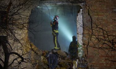 Rescuers search for victims after a drone hit a residential building overnight in Kyiv