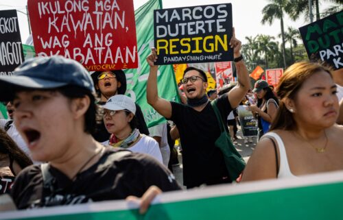 A woman rows a boat on a flooded street following heavy rains in Hoi An